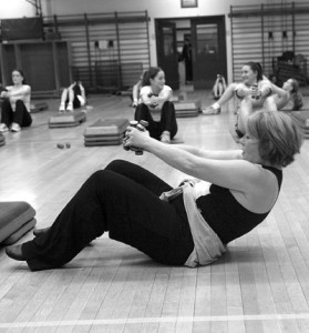 Maureen Maguire (above, center), a fitness instructor at Payne Whitney, leads her Tuesday evening Cardio Conditioning class in weighted pushups. Maguire's class is a twist on traditional step aerobics that maximizes workout efficiency by adding light hand weights to various routines and exercises.