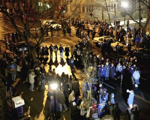 Unionized workers and members of the Graduate Students and Employees Organization form a woman symbol in the intersection of High and Elm streets at a rally Wednesday night. Demonstrators, 100 of whom were arrested, challenged the University to expand childcare and healthcare benefits for women.