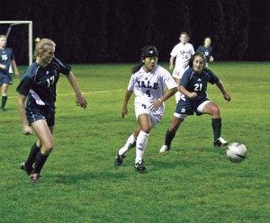Midfielder Christina Huang ’07 splits a pair of Dartmouth defenders last night at Soccer-Lacrosse Stadium. Huang scored on a direct kick as the Elis beat the Big Green, 2-1, propelling the Bulldogs back to the top of the conference standings. A win Saturday against Brown guarantees Yale the 2005 Ivy title.