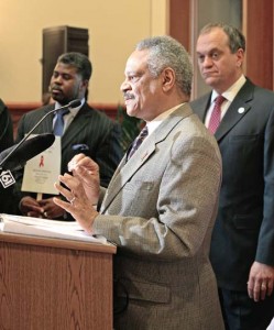 Matthew Lopes ’72, the chair of the Mayor’s Task Force on AIDS, argues against proposed cuts in the program’s funding. DeStefano stands in the background.