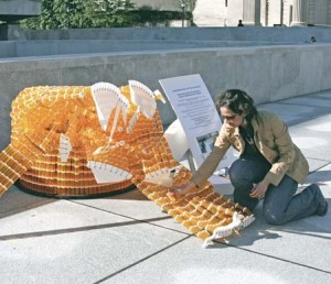 Ami Parekh MED ’09 kneels over a vandalized statue that had previously represented those who die as a result of lack of medicines.