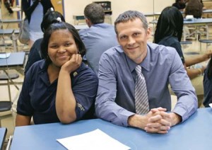 Amistad Academy principal Matt Yalor sits with a student in the school cafeteria. Amistad is a public charter school that is striving to close the achievement gap between socioeconomic groups.