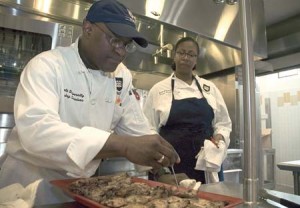 Frank Douglass Jr., a candidate for Ward 2 alderman and a Trumbull dining hall cook, checks up on just-prepared chicken breasts.