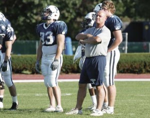 Jack Siedlecki stands with players on the sidelines during a football practice. Yale’s coaches have far less job security than professors.