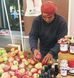 A vendor at the CitySeed farmers’ market organizes apples. The Wooster Square location has been recognized by USA Today for its food and devotion to accessibility.