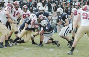 Yale defensive backs Nick Solakian '08 (10) and Paul Rice '10 (5) tackle Harvard running back Gino Gordon during the Crimson's 37-6 rout on November 17.