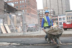 Construction workers clear debris from the Dec. 12 Chapel Street fire. Plans for the area's restoration have been enmeshed in argument.