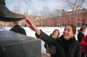 A prospective student rubs the statue of Theodore Woolsey, which brings good luck, according to tour-guide legend.