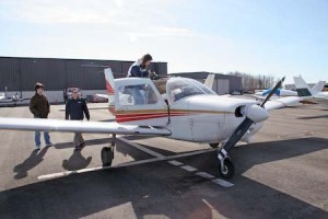 Simone Berkower ’09 climbs on a plane, while Jeff Muskus ’07 watches at Tweed New Haven Airport, whose renovation is facing challenges.