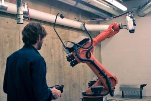 Robots in the basement of the art and architecture building. Joshua Rowley, manager of the fabrication labs and instructor, maneuvers the robot.