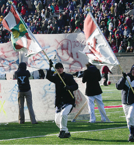 Members of the Yale Precision Marching Band hoist a graffiti-covered model of the Berlin Wall during the band’s halftime show at The Game.
