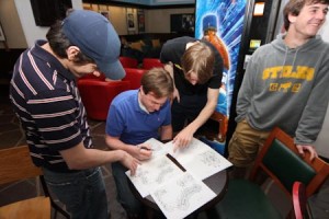 Hazael Montanaro ’10, Quinlan O’Connor ’10 and Adam Lukasiewicz ’10 carefully inspect housing maps while selecting their senior year accommodations during the Ezra Stiles College room draw in the college’s common room Monday night.