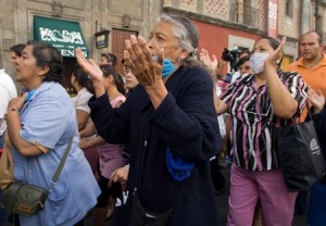 People, wearing surgical masks to ward off infection by the swine flu virus, take part in a procession in Mexico City on Sunday.