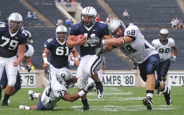 Running back Alex Thomas '12 slips through two Hoya defenders on his way to the endzone.