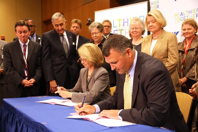 The CEOs of Yale-New Haven Hospital and the Hospital of Saint Raphael signed paperwork Tuesday that made the merger of their hospitals official.
