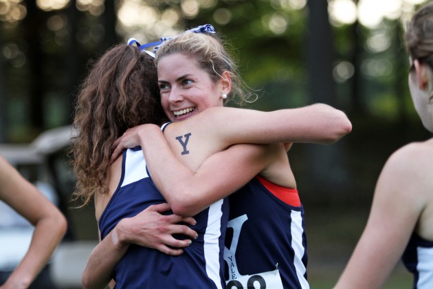 Liana Epstein ’14 embraces a teammate after her first-place finish in Yale’s dual meet against Harvard on Friday.
