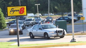 A police convoy leaves the Super 8 motel in Cromwell, Conn., with Raymond Clark III handcuffed in the black car second from the right.