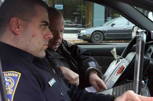 Police, pictured here on patrol last week, have started searching students as they leave liquor stores and asking them to show ID.