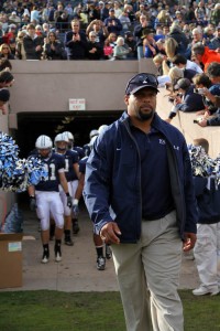 Coach Tom Williams leads the football team onto the field before Yale's game against Harvard
