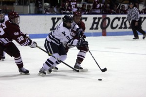 Forward Brian O'Neill '12 battles two defensemen for the puck during Yale's 4-3 overtime loss to No. 10 UMass at Ingalls Rink on Nov. 19.