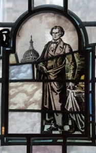 A portion of this pane once depicted slaves (beneath the figure of John C. Calhoun) but has since been replaced with the colored glass in the bottom left corner.