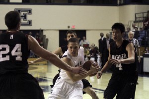 Three Harvard players surround guard Austin Morgan ’13 as he makes a move toward the basket.