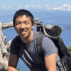 Kevin Jiang smiling at the camera during a daytime hike