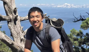 Kevin Jiang smiling at the camera during a daytime hike