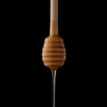 Honey dripping off of a wooden utensil