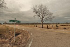 A rural intersection with a field across the road