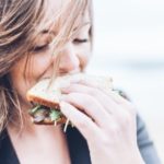 A woman smelling a sandwich