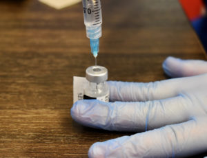 A medical worker fills a syringe with a COVID-19 vaccine dose.