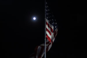 An American flag flies in the night.