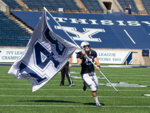 Football player carries flag on field